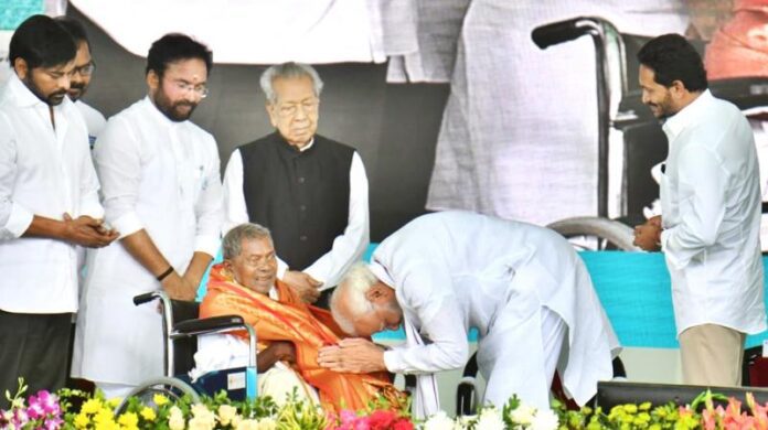 Prime Minister Narendra Modi bowed his head before successor of Mallu Dora, who was follower of freedom fighter Alluru Seetharama Raju, during the Alluri's 125th birth anniversary celebrations at Peda Amiram in Bhimavaram of West Godavari district on Monday. From Left, Actor Chiranjeevi, Union Minister of Tourism G.Kishan Reddy, AP Governor B.Harichandan and Chief Minister Y.S.Jaganmohan Reddy are seen. (Photo: By Arrangement)